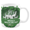 White ceramic 11oz mug featuring a lush green forest scene with silhouettes of wildlife, including elephants, giraffes, deer, and birds, accompanied by the text "World Wildlife Day," celebrating nature and biodiversity.