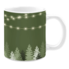 White 11oz ceramic mug featuring a forest green background with a silhouette of evergreen trees at the base. The design is accented with strings of glowing white fairy lights, creating a cozy and festive atmosphere.