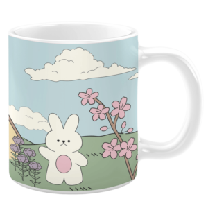 White ceramic 11oz mug featuring a charming spring scene with a cute white bunny holding a pink egg, surrounded by blooming pink cherry blossoms and purple flowers, set against rolling green hills under a soft blue sky with fluffy clouds.