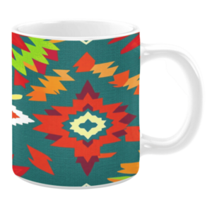 White ceramic mug featuring a Southwestern-inspired pattern with bold geometric shapes in vibrant hues of red, green, yellow, and orange, set against a teal background, creating an energetic and colorful design.