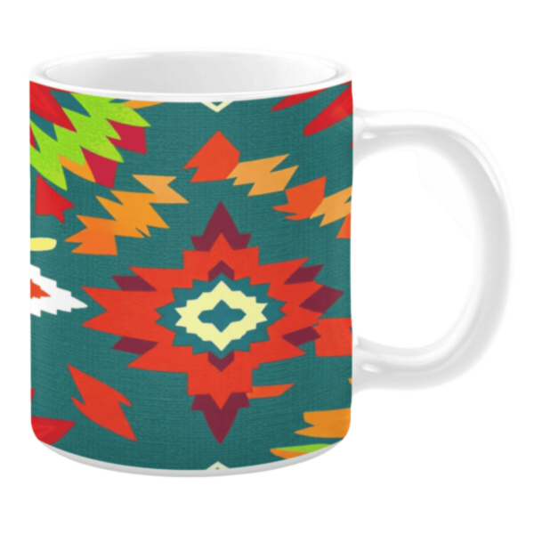 White ceramic mug featuring a Southwestern-inspired pattern with bold geometric shapes in vibrant hues of red, green, yellow, and orange, set against a teal background, creating an energetic and colorful design.