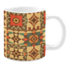 Ceramic mug with a vibrant patchwork of geometric patterns in earthy tones, featuring starbursts, diamonds, and symmetrical shapes in red, green, orange, and beige.