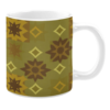 Ceramic mug with a muted olive green background featuring brown and gold starburst patterns alongside yellow diamond accents.