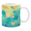 White ceramic mug featuring a serene underwater-inspired design with overlapping circles in shades of blue, green, and yellow, accented by subtle sea creatures like a turtle and delicate floral patterns, creating a dreamy and tranquil aesthetic.