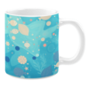 Ceramic mug featuring an underwater-themed design in soft pastel tones. The artwork includes light beige and striped fish, coral-like plants, and abstract bubble patterns, set against a serene turquoise background. Accents of orange and navy enhance the aquatic ambiance, while delicate star and shell motifs complete the marine composition.