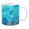 White ceramic mug featuring an intricate underwater design with vibrant sea life, including a whale, fish, coral, and aquatic plants, all illustrated in shades of blue, green, and orange, creating a serene ocean-inspired aesthetic.