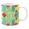 Colorful ceramic mug with geometric patterns in green, yellow, red, and blue tones