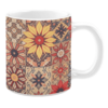 Colorful ceramic mug with floral and tapestry-inspired patterns in red, yellow, and beige tones