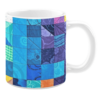 Colorful ceramic mug with patchwork patterns in blue, purple, and orange tones