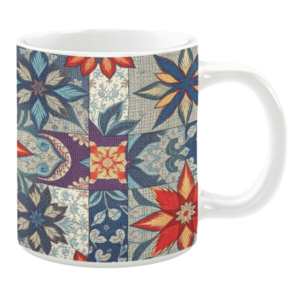 Colorful ceramic mug with floral quilt-inspired patterns in blue, red, and beige tones