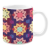 Colorful ceramic mug with star-shaped quilt patterns in purple, pink, yellow, and green tones