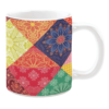 White ceramic mug featuring a vibrant patchwork quilt design with floral and geometric patterns in rich colors such as red, yellow, green, and blue, creating a bold and energetic aesthetic.