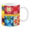 Colorful ceramic mug with quilt-inspired geometric and floral patterns in red, yellow, blue, and green tones