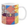 Colorful ceramic mug with quilt-inspired patterns in red, blue, yellow, and orange tones