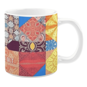 Colorful ceramic mug with quilt-inspired patterns in red, blue, yellow, and orange tones